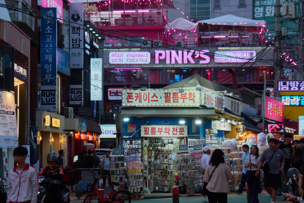 Shops, signs and pedestrians on a Hongdae street at night